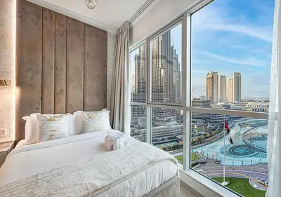 a bedroom with a bed and a large window at Livin' Holidays - 2 BR - Burj Khalifa & Fountain in Dubai