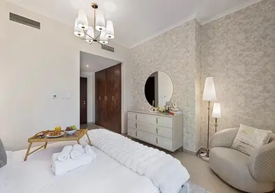 a bedroom with a large white bed and a mirror at Livin' Holidays - 2 BR - Burj Khalifa & Fountain in Dubai