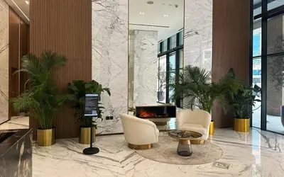 a lobby with two chairs and a fireplace at Waves - Luxe Studio with Jacuzzi & City Views in Dubai