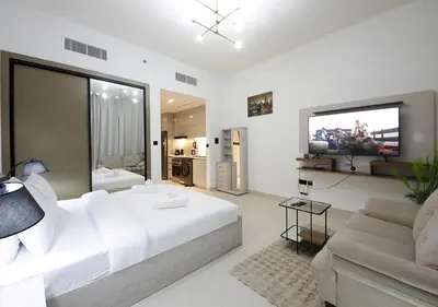 a white bedroom with a large bed and a couch at Elegant Studio in Binghatti Canal, Downtown Access in Dubai