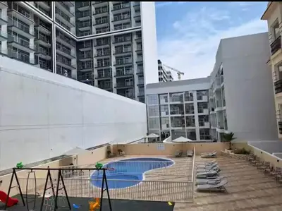 a building with a swimming pool in a city at Ayla Residence 1 in Dubai