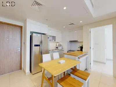 a kitchen with a wooden table and a refrigerator at Chic 2 Bedroom Apartment - Park Point - Dubai Hills in Dubai
