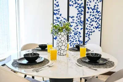 a white table with plates and glasses of orange juice at The Lofts East Unique 1BR Boulevard Views close to Dubai Mall in Dubai