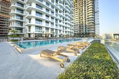 a row of benches next to a swimming pool in a building at Partial Marina and City Views 1BR, Close to JBR Beach, Palace Beach Residence Tower 2,Emaar Beachfront ,Dubai Marina by Deluxe Holiday Homes in Dubai