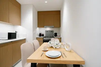 a kitchen and dining room with a wooden table at Luxury Apt and Private Beach with cooled sand in Dubai