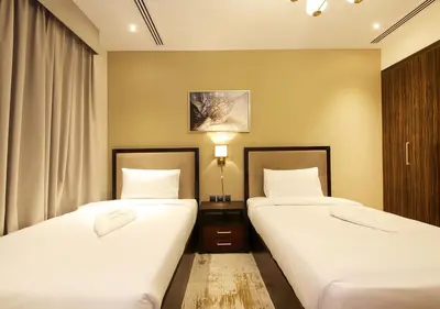 two beds in a hotel room with white sheets at Modern 2BR Apartment Near Dubai Mall with Pool Gym in Dubai