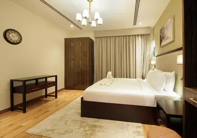 a bedroom with a bed and a desk and a clock at Modern 2BR Apartment Near Dubai Mall with Pool Gym in Dubai