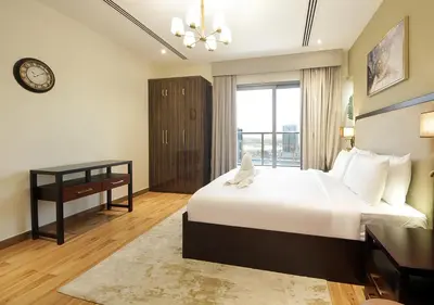a bedroom with a bed and a desk and a window at Modern 2BR Apartment Near Dubai Mall with Pool Gym in Dubai