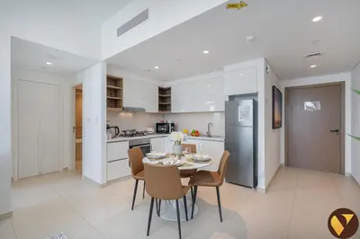 a kitchen and dining room with a table and chairs at Vogue Downtown Views II with Direct Access to Dubai Mall Via a Climate Controlled Bridge, One Bedroom Apartment with Balcony and City View in Dubai