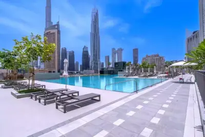 a swimming pool with a city skyline in the background at Vogue Downtown Views II with Direct Access to Dubai Mall Via a Climate Controlled Bridge, One Bedroom Apartment with Balcony and City View in Dubai