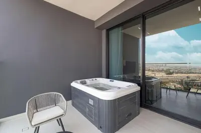 a bathroom with a tub and a chair and a window at New Studio in Business Bay with private Jacuzzi in Dubai