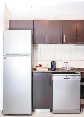 a kitchen with white appliances and brown cabinets at Full Marina view, mins to JBR beach, Ain Dubai, Palm in Dubai