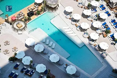 an overhead view of a swimming pool with umbrellas and chairs at Luxury Escapes - Exquisite 3BR plus Maid, Full Sea View in JBR in Dubai