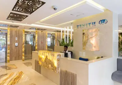 a man sitting at a counter in a lobby at 1Bedroom Apartment with Portable bed in Living Area in Dubai