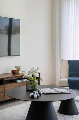 a living room with a table with a vase of flowers at Frank Porter - Murooj Al Furjan West in Dubai