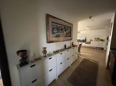 a kitchen with white cabinets and a painting on the wall at Luxury hub in Dubai