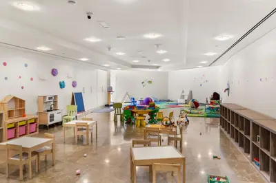 a classroom with tables and chairs and a play area at Luxury Apt DIFC, XL Layout, Pool, Gym, Skyline View in Dubai