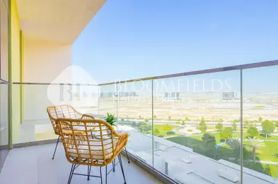 a balcony with two chairs and a view of the desert at Bloomfields 1br Elegant Escape The Pulse in Dubai