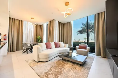 a living room with a white couch and a table at Relax in Style 2BR Huge Terrace Lagoon Access in Dubai