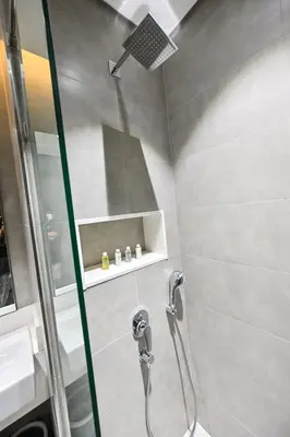 a shower with a glass door in a bathroom at Relax in Style 2BR Huge Terrace Lagoon Access in Dubai