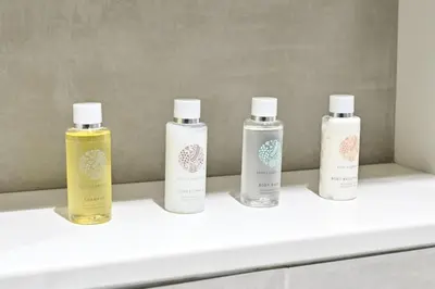 four bottles of essential oils sitting on a shelf at Relax in Style 2BR Huge Terrace Lagoon Access in Dubai