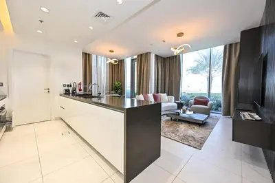 an open kitchen and living room with a couch at Relax in Style 2BR Huge Terrace Lagoon Access in Dubai