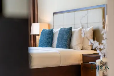 a bedroom with a bed with blue and white pillows at The Prestige in Dubai