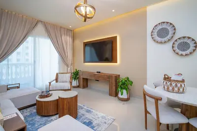 a living room with a tv and a table at Oasis by Tarrab in Dubai