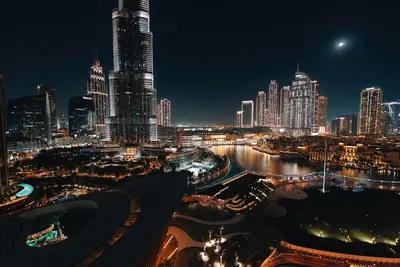 a night view of a city with tall buildings at Stylish 2-Bedroom Luxury Stay in Downtown Dubai with Burj Khalifa & Fountain Views in Dubai