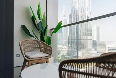 a room with a table and a chair and a window at Stylish 2-Bedroom Luxury Stay in Downtown Dubai with Burj Khalifa & Fountain Views in Dubai