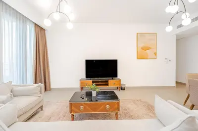 a living room with a couch and a tv at Escape24 Elegant 2BR with Canal view near Safa Park in Dubai