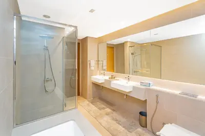a bathroom with two sinks and a shower at Escape24 Elegant 2BR with Canal view near Safa Park in Dubai