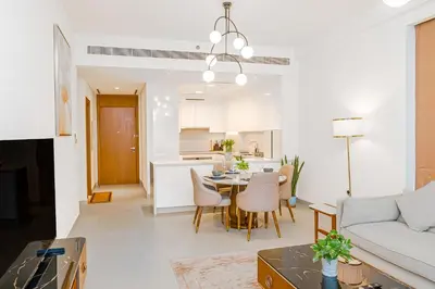 a living room and kitchen with a table and chairs at Escape24 Elegant 2BR with Canal view near Safa Park in Dubai