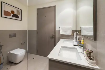 a bathroom with a sink and a toilet and a mirror at Grande 2BR Apartment with Burj Khalifa & Fountain Views in Dubai