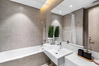 a bathroom with a sink and a bathtub and a white sink at Luxurious 1 BR in District One Beach Access in Dubai
