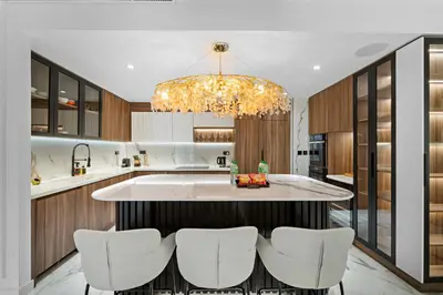 a kitchen with a large island with white chairs at 3BR plus Maid Rimal 4 Direct Beach Access in Dubai