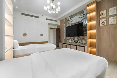 a bedroom with two beds and a flat screen tv at 3BR plus Maid Rimal 4 Direct Beach Access in Dubai
