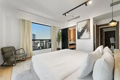 a white bedroom with a large bed and a chair at 3BR plus Maid Rimal 4 Direct Beach Access in Dubai