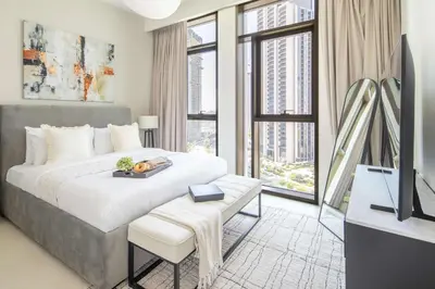 a bedroom with a large bed with a television and a table at Frank Porter - Creek Crescent Tower 1 in Dubai