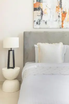 a bedroom with a bed with a lamp and a painting at Frank Porter - Creek Crescent Tower 1 in Dubai
