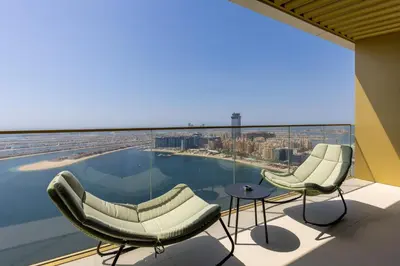 a view from the top of a building with chairs and a pool at Maison Privee - Coastal Living with Uninterrupted Sea & Palm Views in Dubai