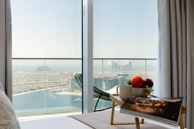 a room with a view of a city from a hotel room at Maison Privee - Coastal Living with Uninterrupted Sea & Palm Views in Dubai