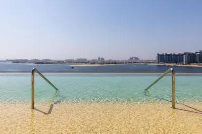 a pool of water with two metal bars in it at Maison Privee - Coastal Living with Uninterrupted Sea & Palm Views in Dubai