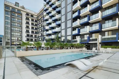 an image of a swimming pool in front of a building at Luxury 1BR JVC Pool & Balcony by Circle Mall in Dubai
