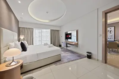 a hotel room with a bed and a desk at Elite Escapes - Glamorous 1BR DAMAC Paramount B in Dubai