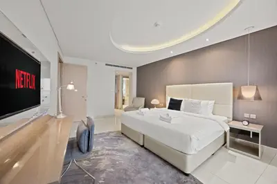 a bedroom with a large bed and a flat screen tv at Elite Escapes - Glamorous 1BR DAMAC Paramount B in Dubai