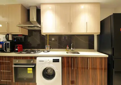 a kitchen with a washer and a sink and a refrigerator at Breathtaking Views from a H-Floor Studio in Dubai in Dubai