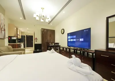 a bedroom with a large bed and a large screen tv at Breathtaking Views from a H-Floor Studio in Dubai in Dubai