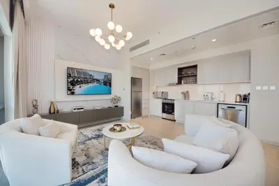a living room with white furniture and a kitchen at Modern 2BR Apartment - Vida Residences Creek Beach - Creek Beach Access in Dubai