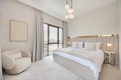 a bedroom with a large bed and a chair at Modern 2BR Apartment - Vida Residences Creek Beach - Creek Beach Access in Dubai